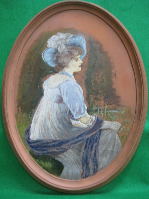 A Watcombe Torquay oval wall plaque painted with an elegant lady wearing a blue feathered hat