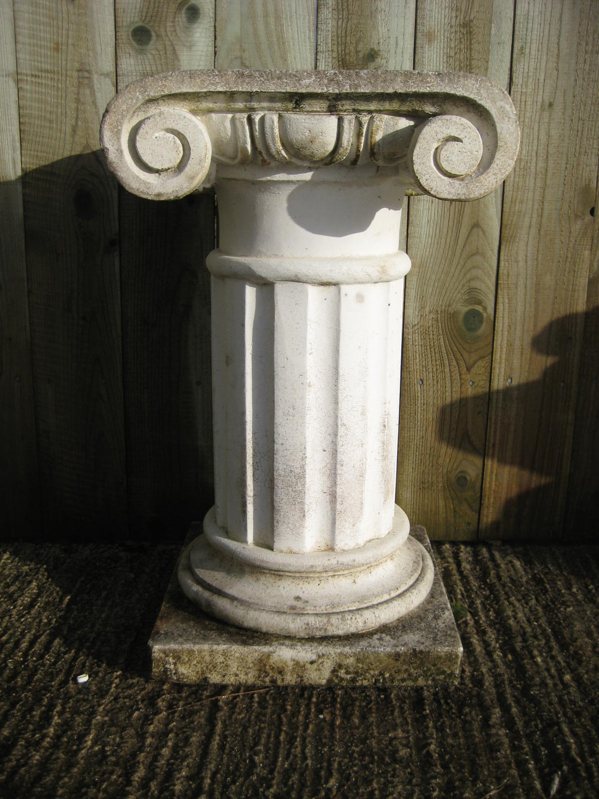 A garden stone column in the form of a classical pillar