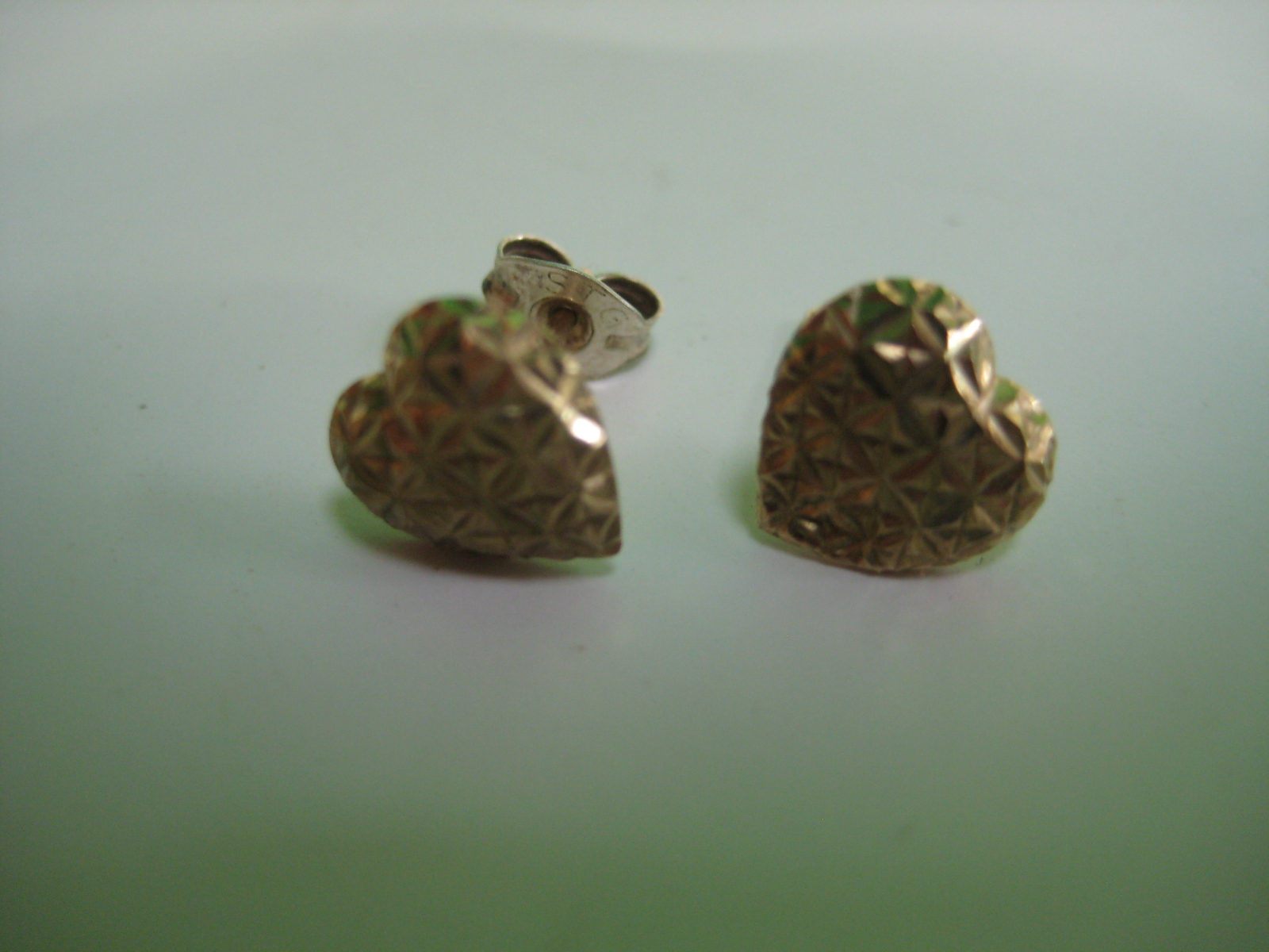 A pair of gold-coloured heart shaped ear-rings