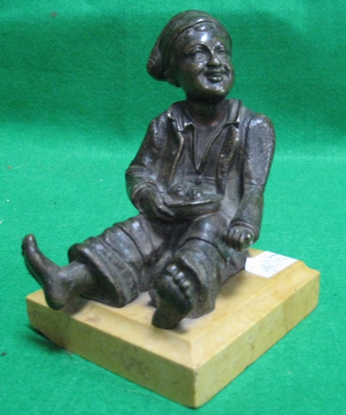 A late 19th Century bronze of a seated beggar boy on marble base