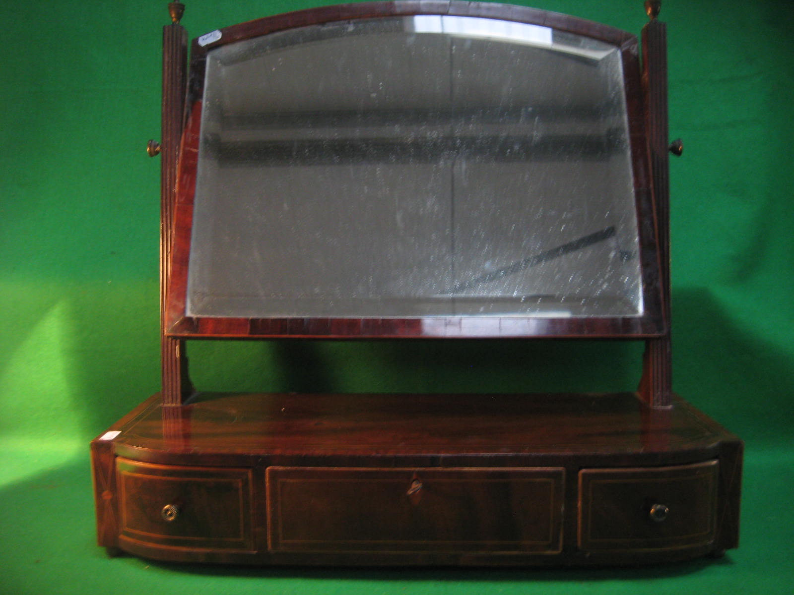 A Georgian mahogany swing frame dressing mirror on bun feet