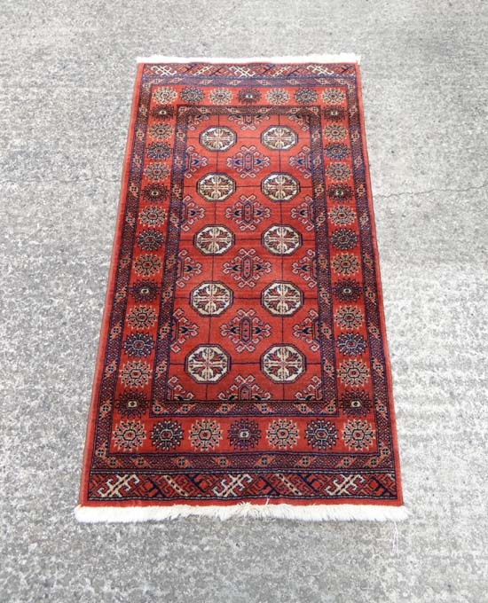 Rug / Carpet : an Afghan Alti Bolak rug with 10 octagonal roundels to the centre on a light wine