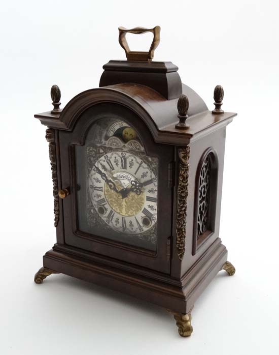 A Contemporary small bracket clock as made by Wuba striking on 2 bells with a break arch case and