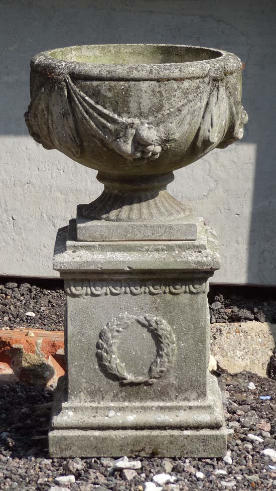 Garden and Architectural : a pedestal urn with swag decoration stood on a squared plinth having