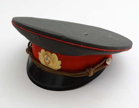 A Russian Soviet Union military hat/visor with a Russian soviet police badge mounted on the front.