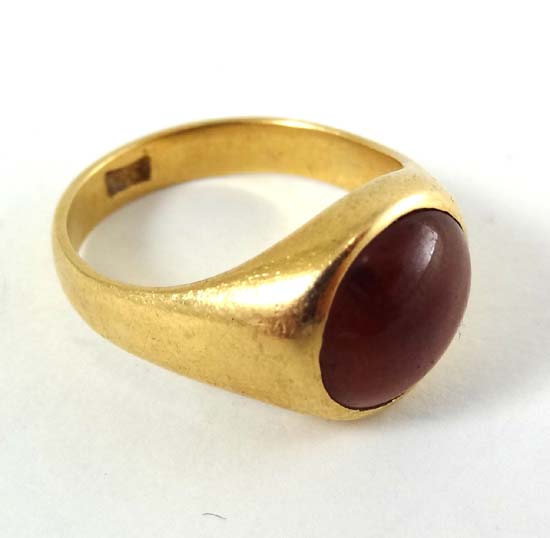An 18ct gold ring set with garnet cabachon to top