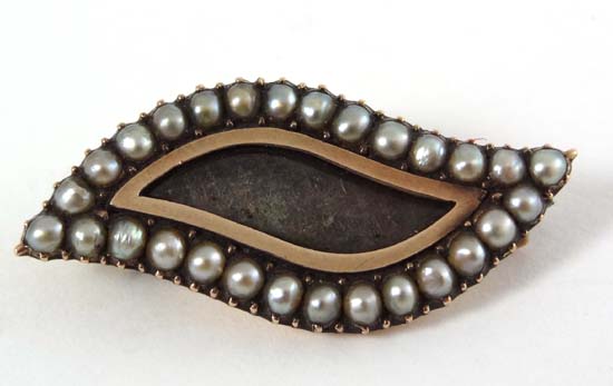 A gilt metal mourning brooch / pendant with shaped central glazed scetion with lock of hair to
