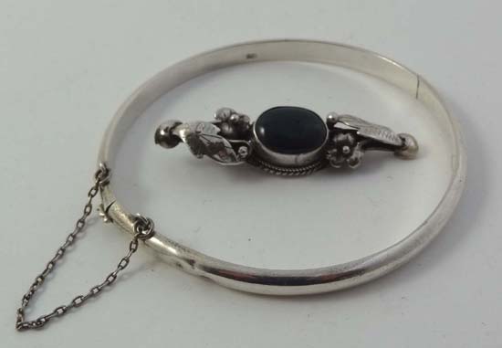 A white metal brooch set with green hardstone cabachon together with a .925 silver bangle (2)