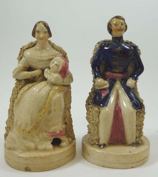 A pair of Victorian Staffordshire seated figures representing Prince Albert and Queen Victoria