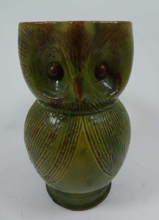 An early 20thC novelty jug in the form of an owl having incised decoration to head and body and