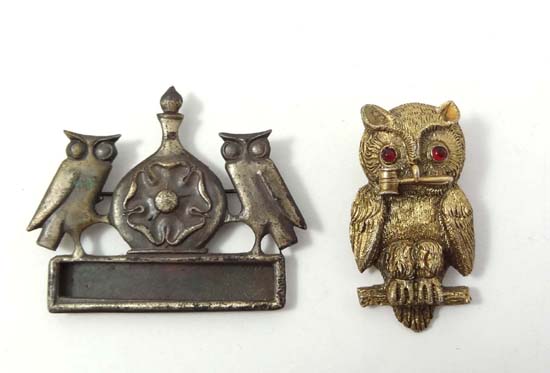A Victorian gilt metal brooch / stud formed as an owl with red glass eyes and holding a gavel in its