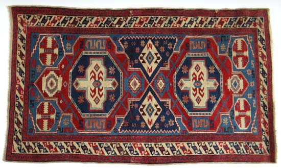 Rug / Carpet : a handmade woollen rug with central two geometric medallions of red, light blue, dark