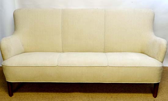 Vintage Retro : a Danish three seat cream upholstered sofa with low arms and shaped bow fronted