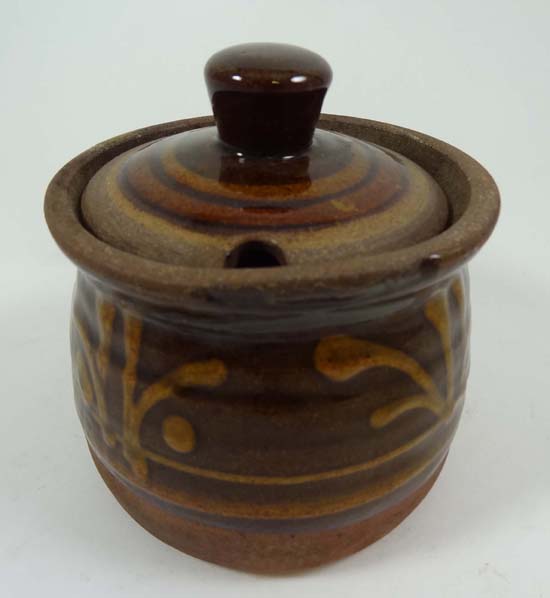 A Studio pottery slip decorated stoneware conserve jar and cover, decorated with honey coloured slip