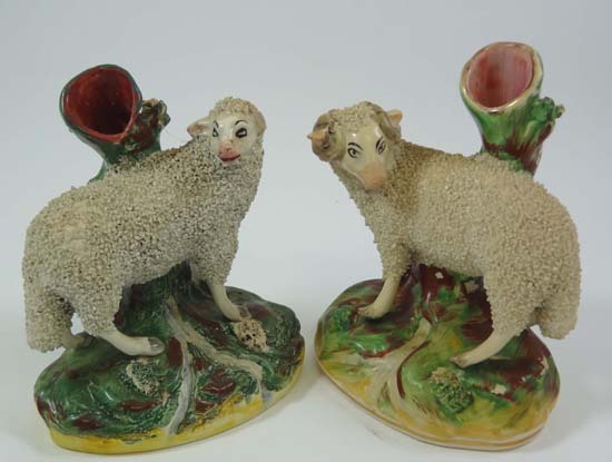 Victorian Staffordshire spill vases depicting a ewe and a ram decorated with granular glazes.