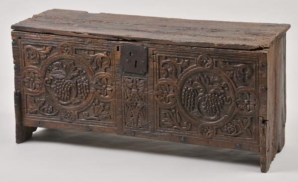* An early oak coffer, probably 17th century, the rustic rectangular top over front panel, profusely