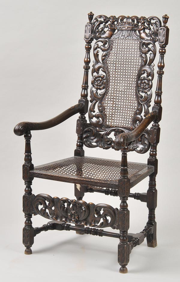 * A 17th century style ‘Boys and Crown’ armchair, with downward scrolls, acanthus carved arms and