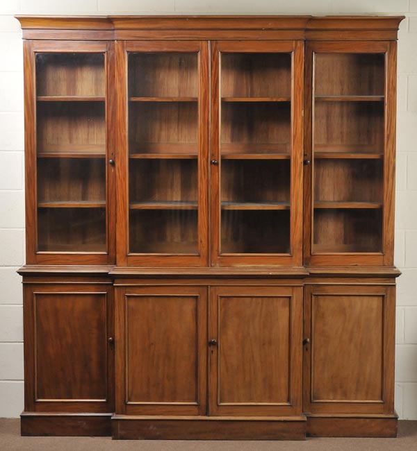 * A Victorian mahogany breakfront bookcase, with four glass doors enclosing shelved interior over