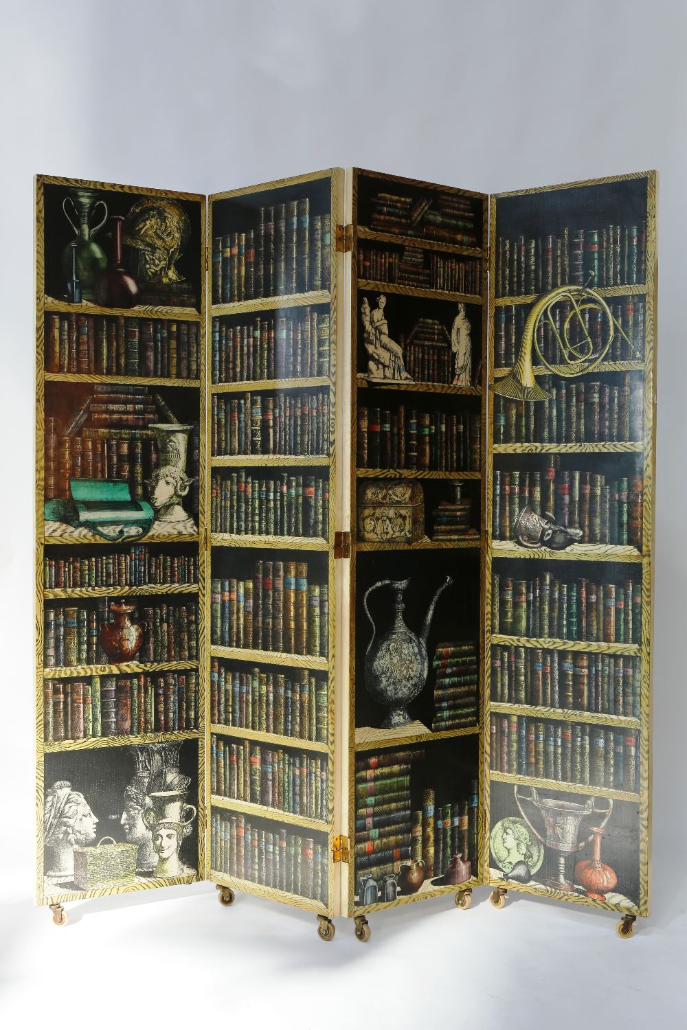 PIERO FORNASETTI: A four panel trompe l`oeil "library" or "books" screen, with four hinged panels