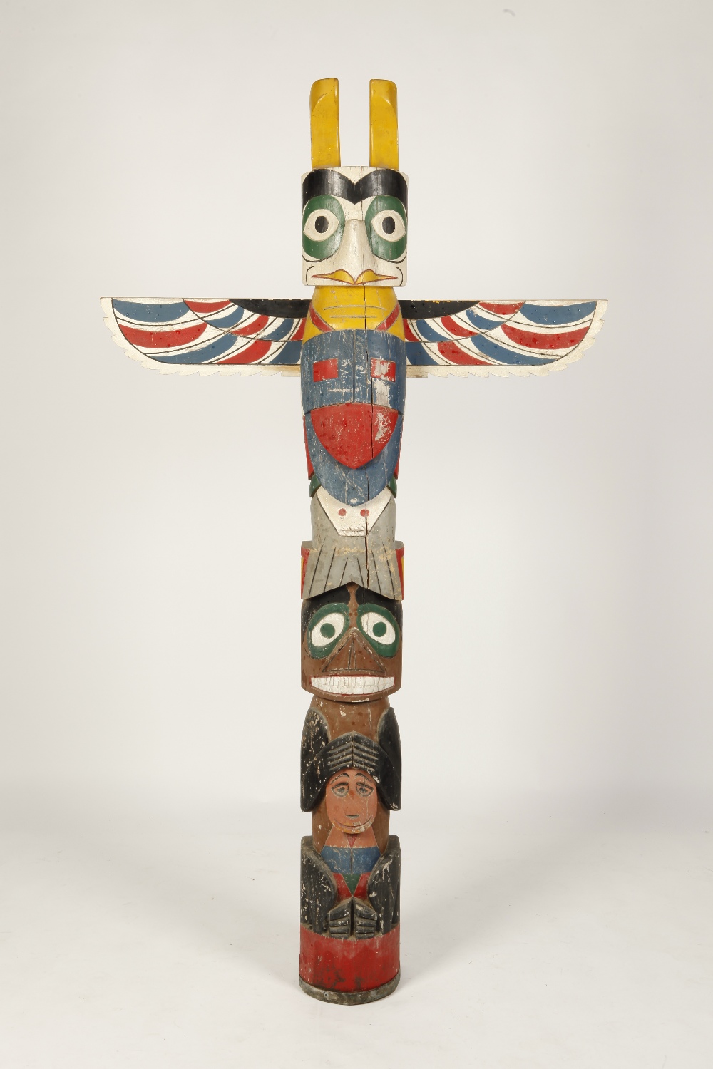 A NORTH WEST PACIFIC TOTEM POLE carved with a beaver, a bear and a whale surmounted by an eagle with