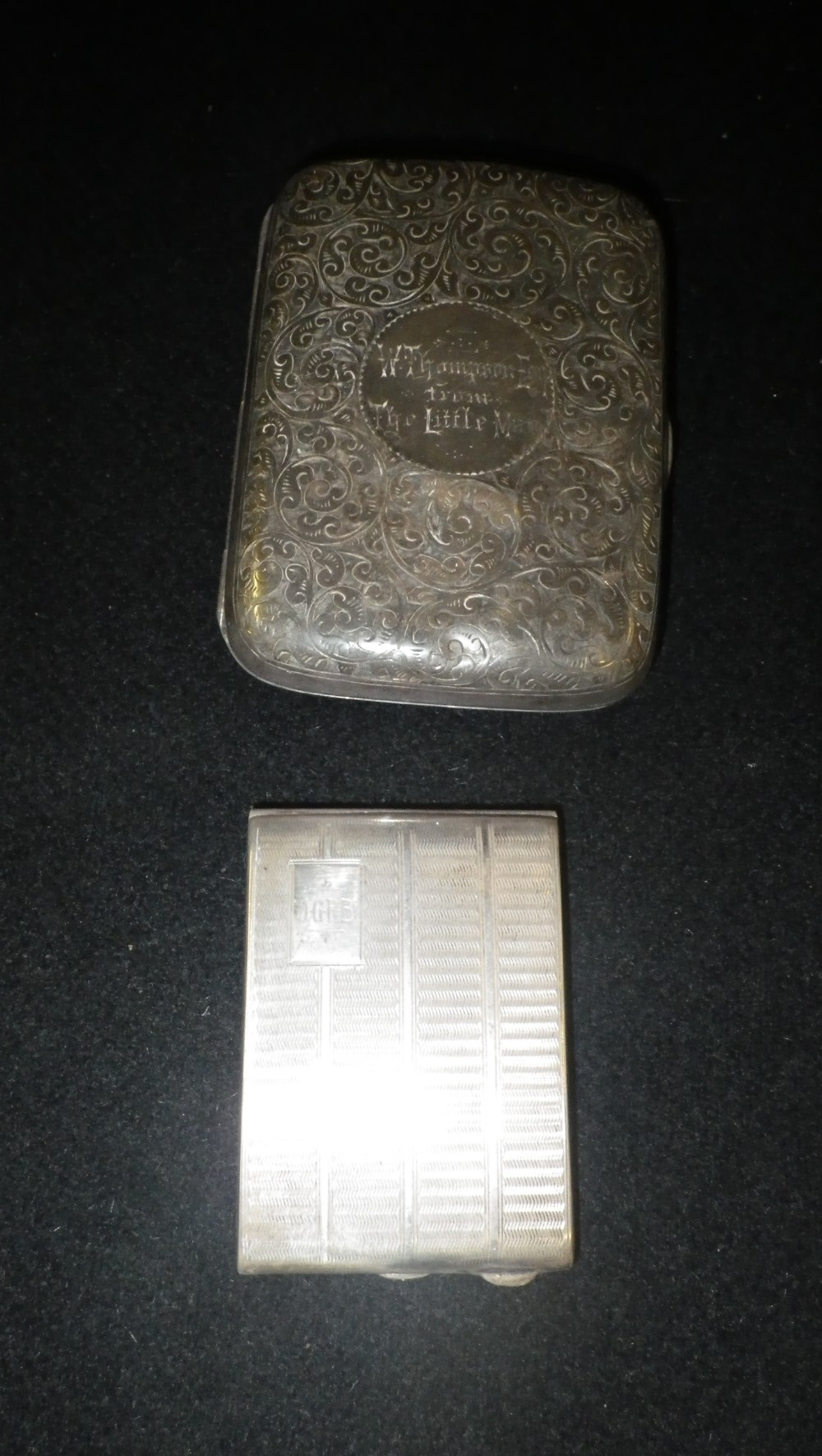 A scroll engraved silver cigarette case and an engine-turned silver matchbox case (2)