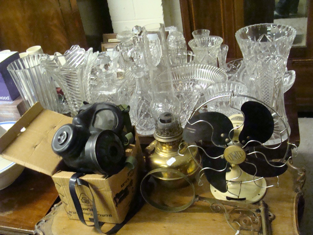 A vintage Limit electric fan, a gas mask and a brass oil lamp with associated bracket