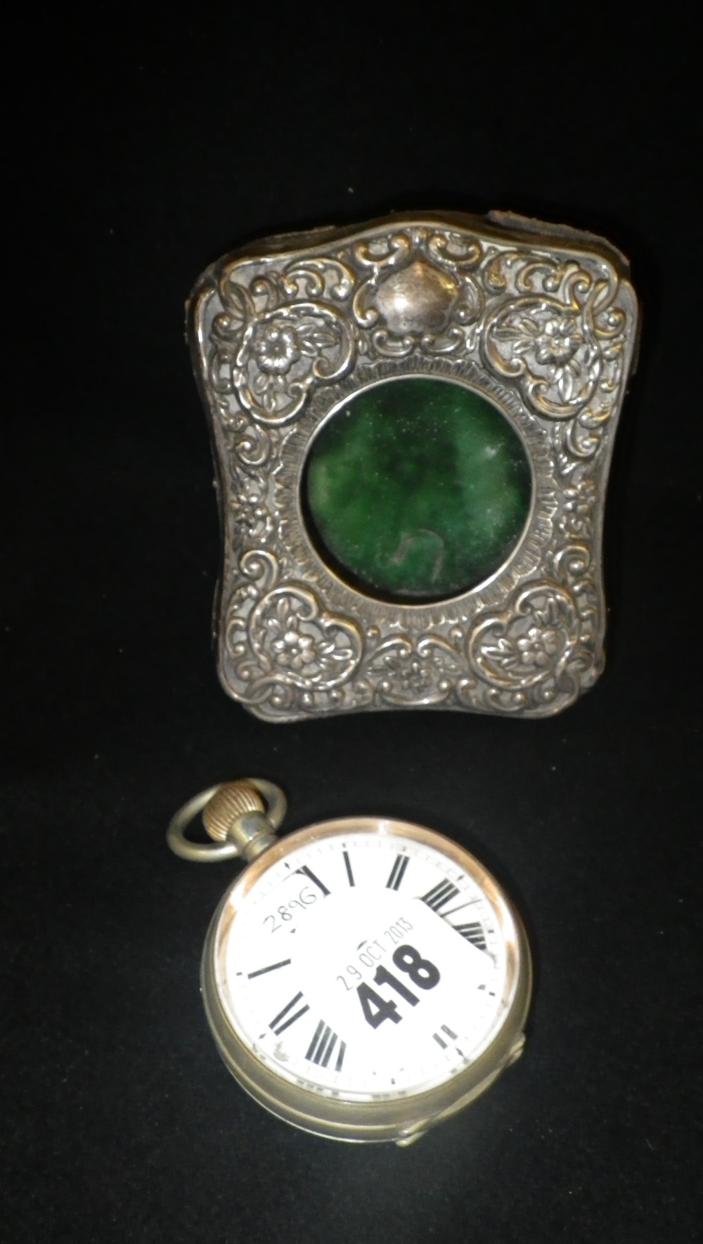 A white metal railway style pocket watch in a silver mounted easel-back frame