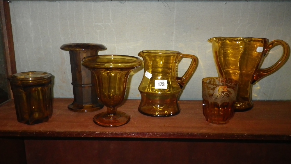 An amber glass with etched decoration and a collection of similar glassware