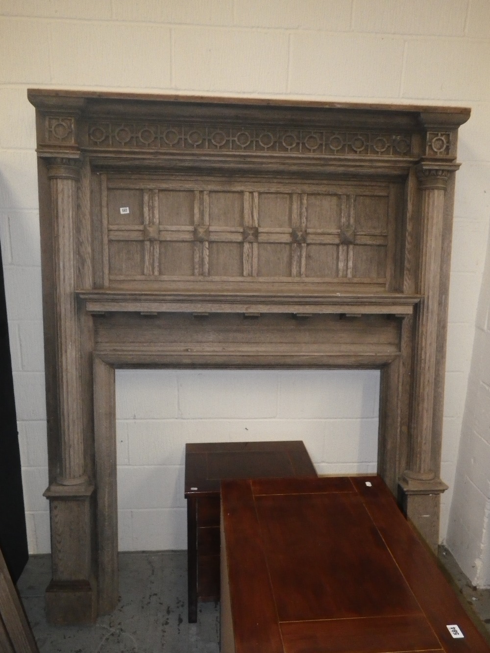 An early 20th century Jacobean Revival fire surround with fluted columns and panelled decoration