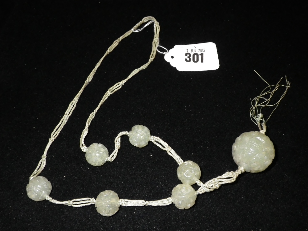 An Art Deco style carved `Jade` tassel necklace, knotted silk thread