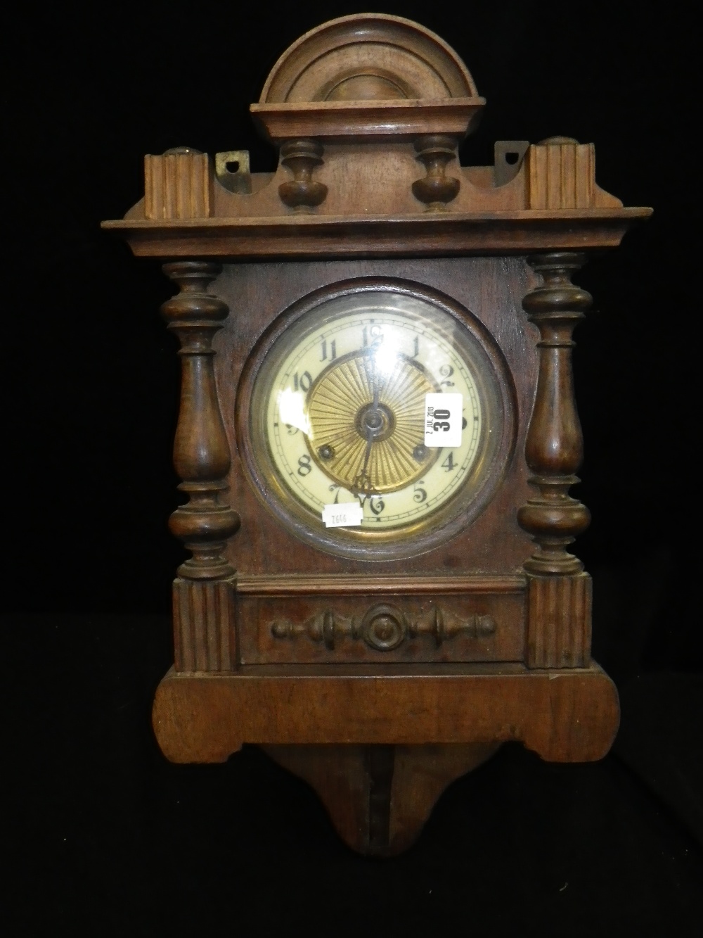 A late Victorian walnut cased wall clock, with turned decoration