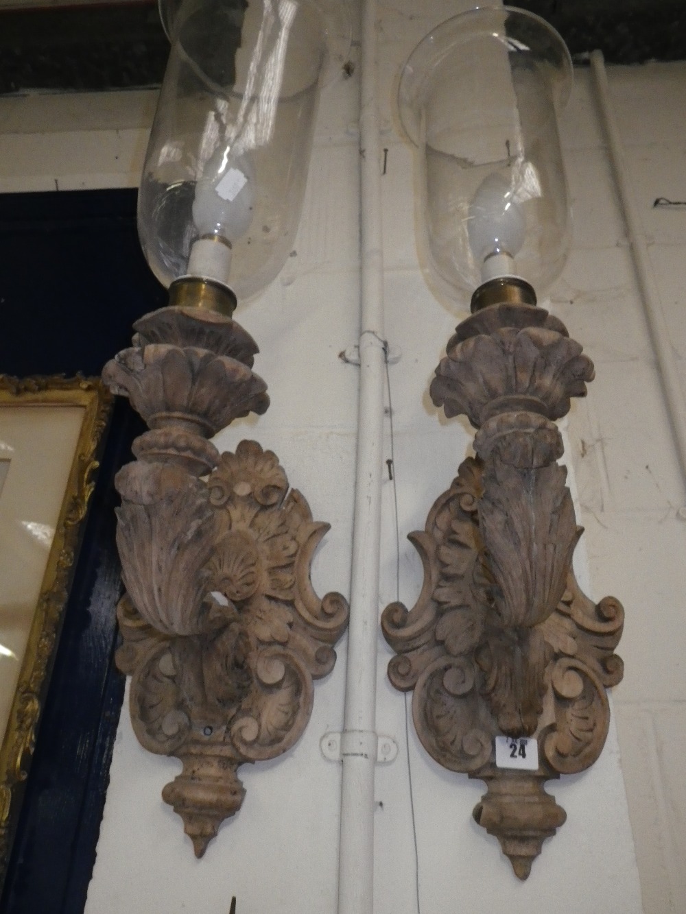 A pair of baroque style carved wooden wall sconces, fitted for electricity, with glass shades