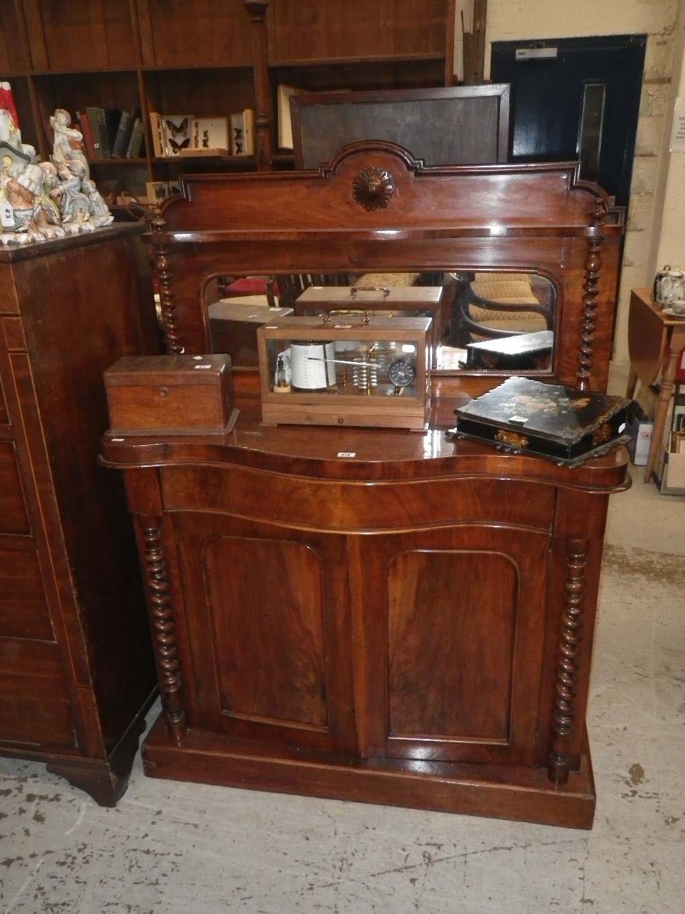 A Victorian mahogany chiffonier with a raised mirrored back above a serpentine front and shaped