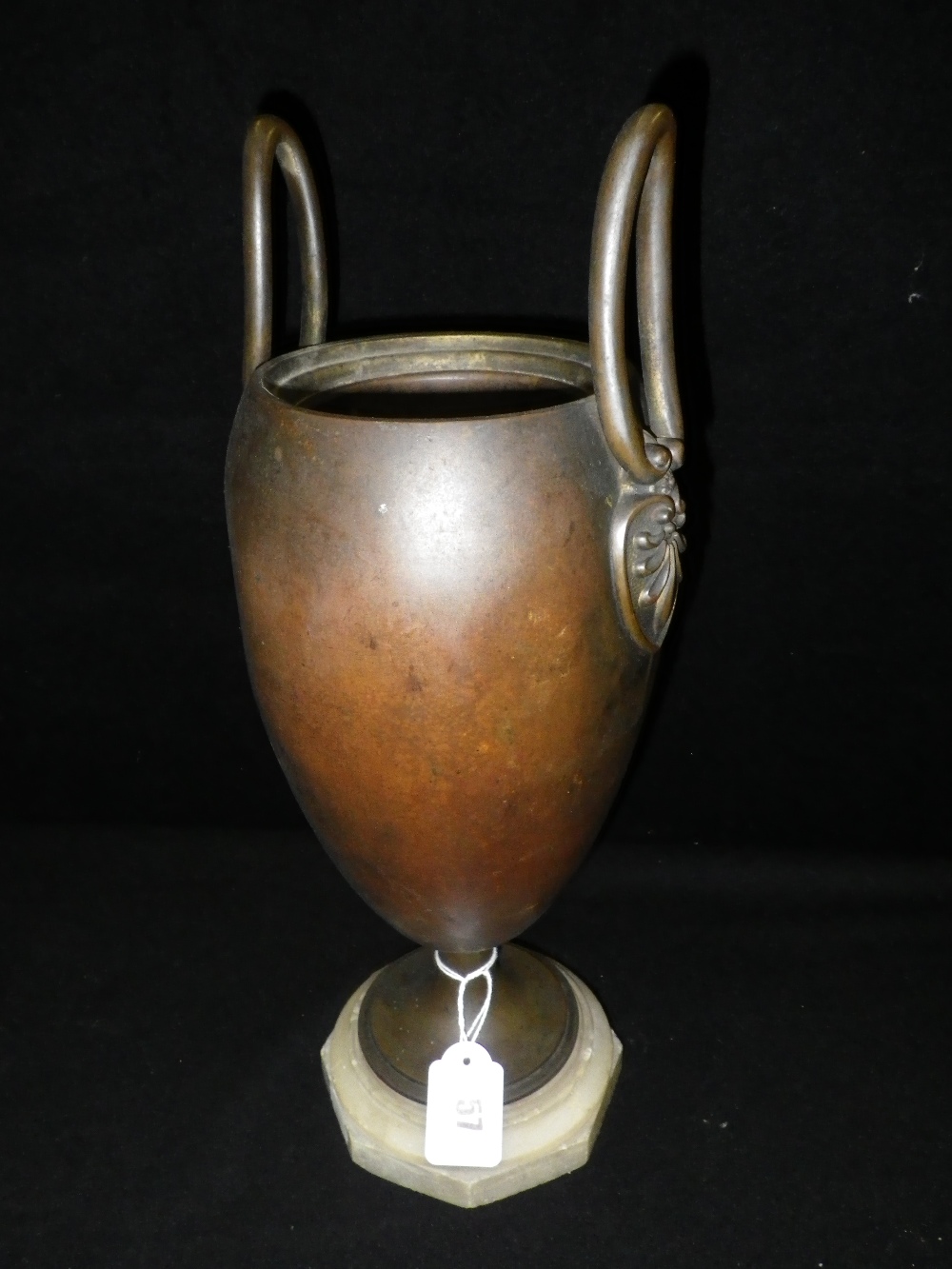 A Regency design patinated bronze effect urn on a marble base
