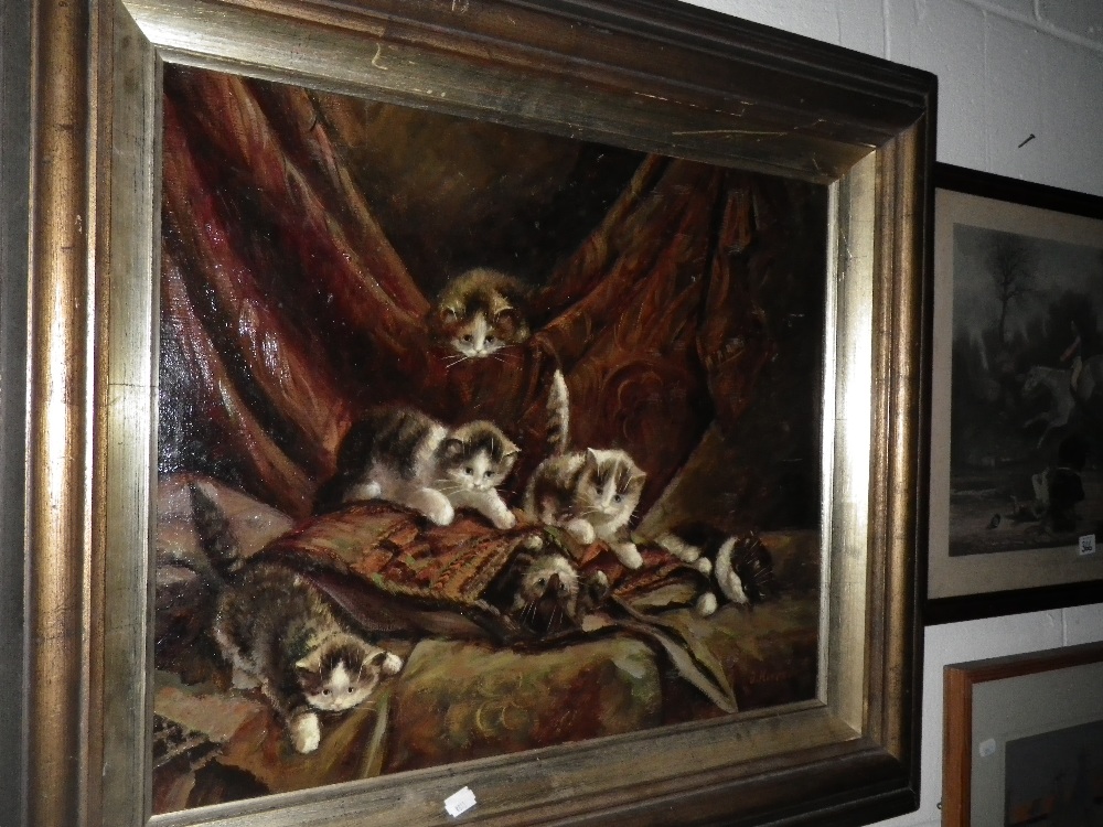 An oil on canvas depicting kittens playing in a carpet saddlebag, indistinctly signed