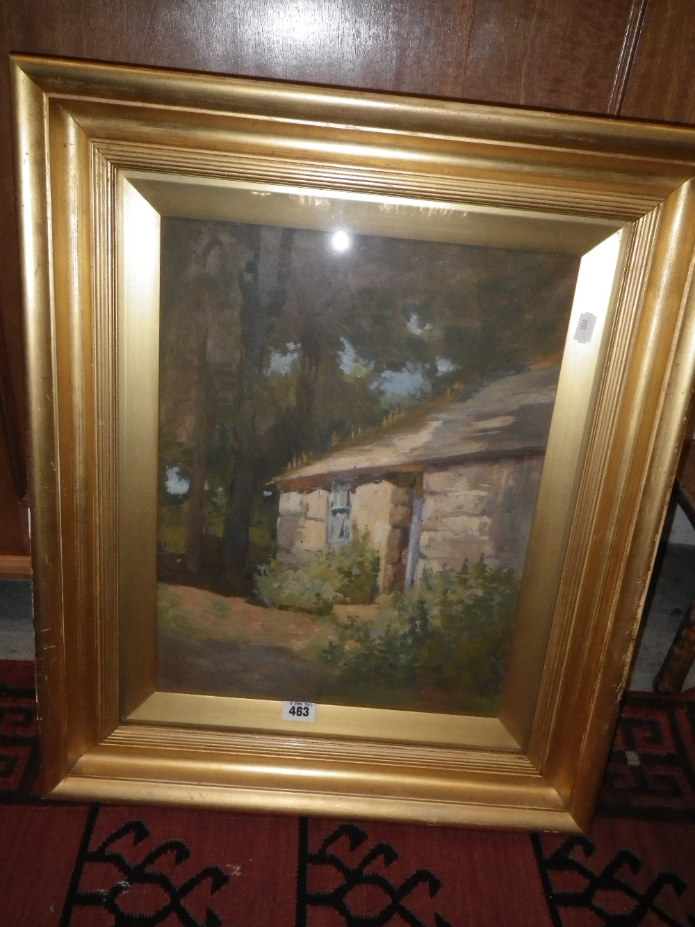 An oil on canvas view of a cottage in woodland, the canvas with a back stamp from a St. Ives