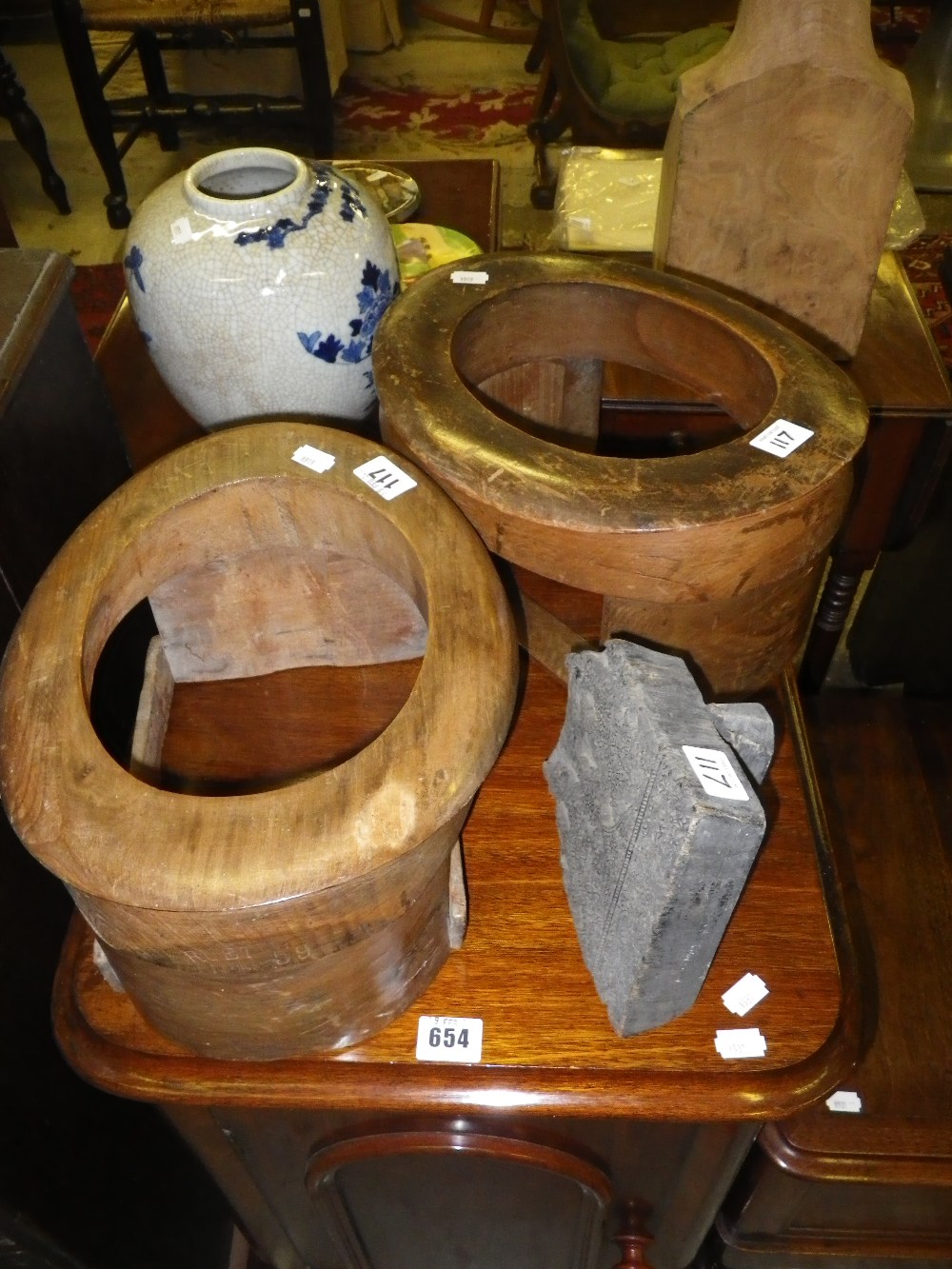 A pair of wooden top hat holding frames and an Indian block stamp