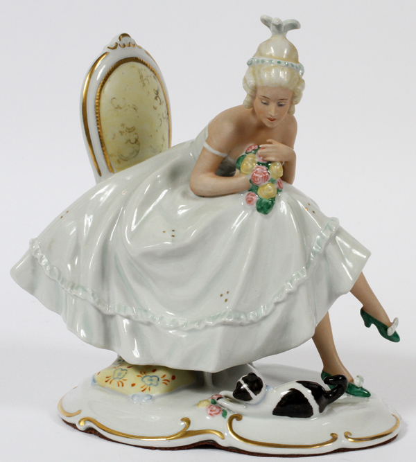 SCHAUBACH KUNST, GERMAN PORCELAIN FIGURE, C. 1930, H 7 3/4", W 7": A young woman seated on a chair