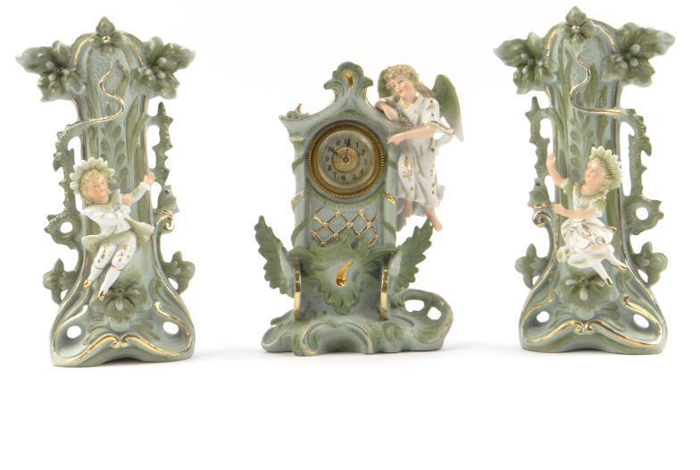 Victorian bisque china three piece clock garniture, the clock and vases surmounted with children and