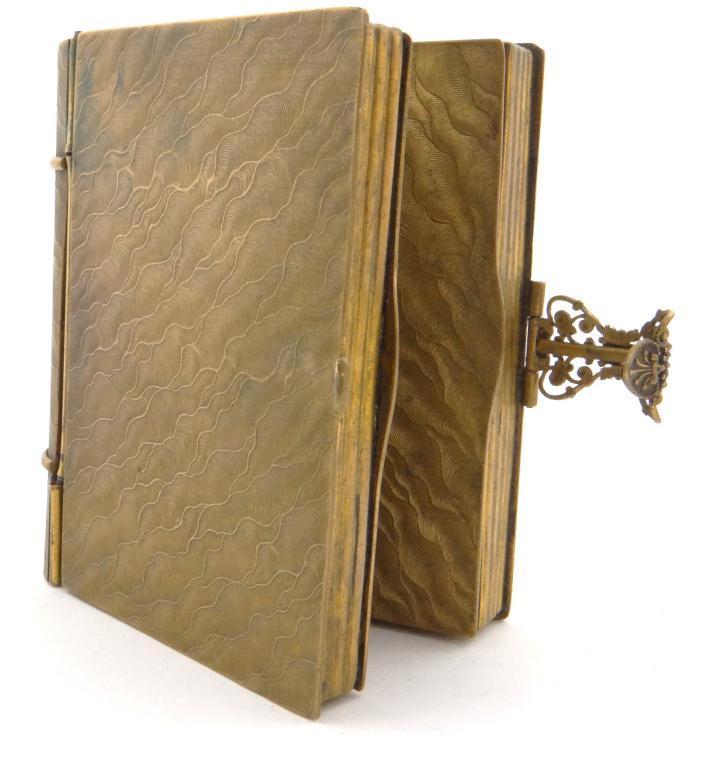 Brass book shaped twin compartment compact with mirrored interior and engine turned outer case,