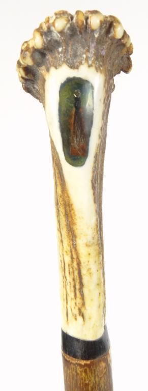 Bone handled wooden walking cane, the grip set with a fishing lure, 127cm high : For Condition