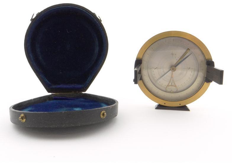 Brass cased compass with silvered dial, folding sights and blued steel hand, housed in a velvet