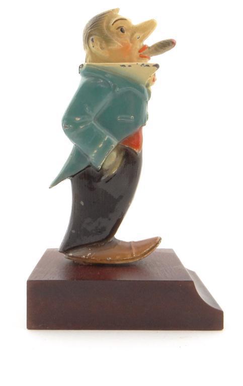 Novelty painted spelter figural table lighter raised on a mahogany plinth base, 12cm high : For