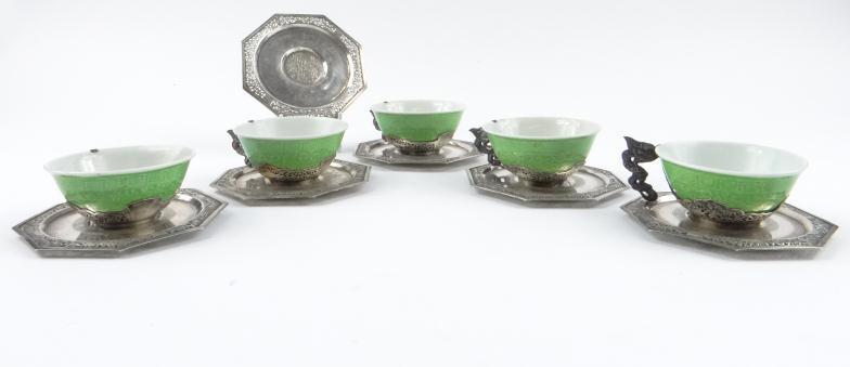 Five Vietnamese 900 grade silver mounted porcelain tea cups and six saucers, the cups with dragon