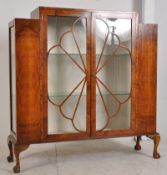 A 1930's Art Deco walnut bookcase / display cabinet. The decorative shaped upright body with
