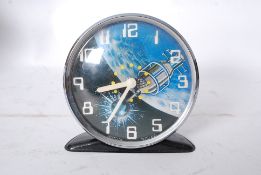 A retro Westclox tinplate alarm clock, with ticking satellite decoration to face.
