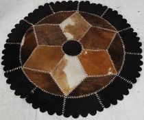 An Australian cow hide / leather circular patchwork rug, stamped to verso
