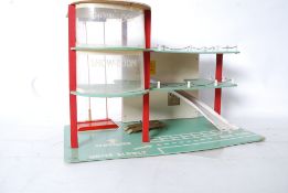 A vintage wooden constructed toy garage, with miniature chain link guard rails and moving elevator