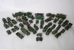 A large collection of Dinky diecast military vehicles, each in army green colouring. Some