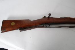 A 6.5mm Mausser deactivated old specification rifle dated 1902 plus leather sling. Correct bayonet